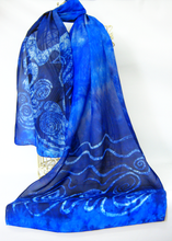 Load image into Gallery viewer, A_vibrant_blue_scarf_with_swan_and_celtic_design_inspired_by_the_Children_of_Lir_draped_over_a_wire-body_in_front_of_a_white_backroung