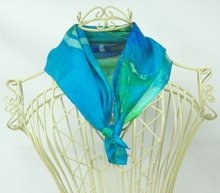 Load image into Gallery viewer, silk_scarf_worn_on_a_cream_colouredmannequin_infront_of_a_white_background_a_small_neck_scarf_or_pocket_scarf_or_bag_scarf