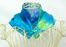 Load image into Gallery viewer, silk_bandana_in_shades_of_turquoise_blue_green_and_yellow_worn_on_the_neck_of_a_cream_coloured_wire_mannequin_a_lovely_small_gift_idea_from_Ireland