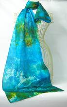 Load image into Gallery viewer, 
A_silk_scarf_hand_painted_in_the_art_of_batik_in_bright_turquoise_blues_and_teal_green_with_flashes_of_golden_orange
