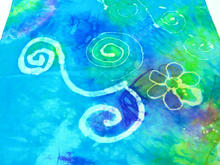 Load image into Gallery viewer, A_close_up_image_of_the_silk_bandana_featuring_Celtic_spirals_and_a_flower_in_turquoise_blends_with_flashes_of_yellow_and_bright_green_and_magenta
