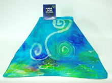 Load image into Gallery viewer, silk_scarf_draped_over_a_box_with_the_madelocal_silgn_on_top_this_small_bandana_style_scarf_with_a_spiral_and_flower_design_would_be_the_perfect_small_gift
